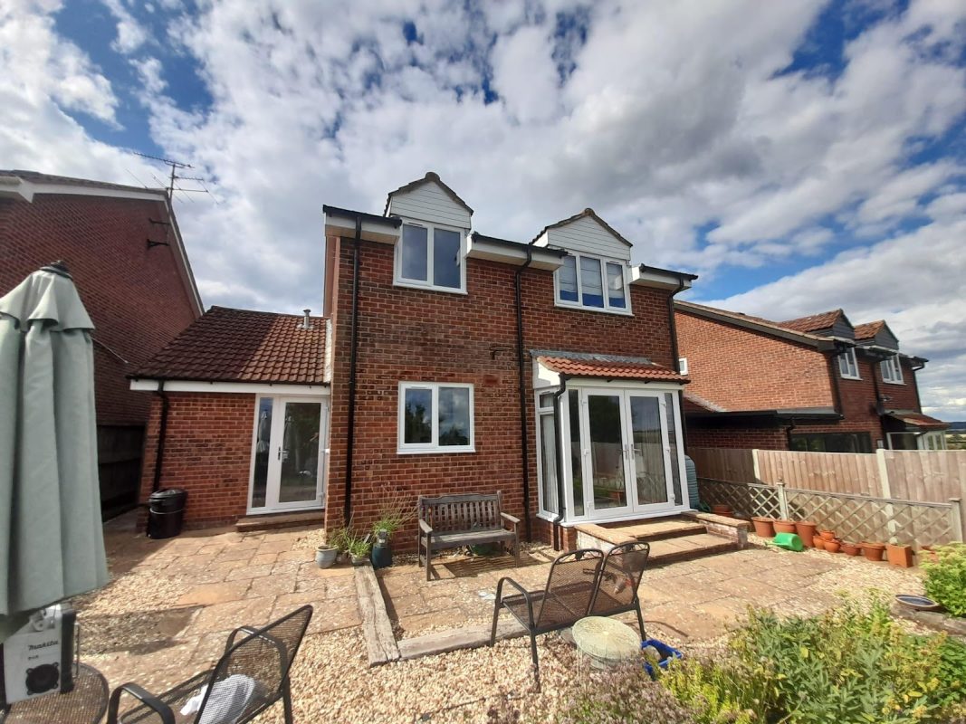 White window frames as part of a brick house.